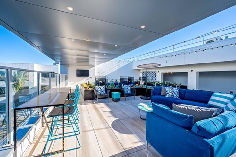 a living room with blue couches and chairs and a table